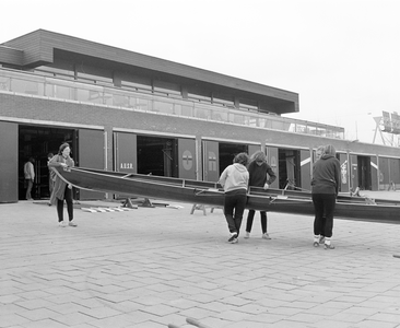 882262 Afbeelding van enkele roeisters die een boot sjouwen, bij de roeiaccomodatie aan de Vaartsche Rijn (Verlengde ...